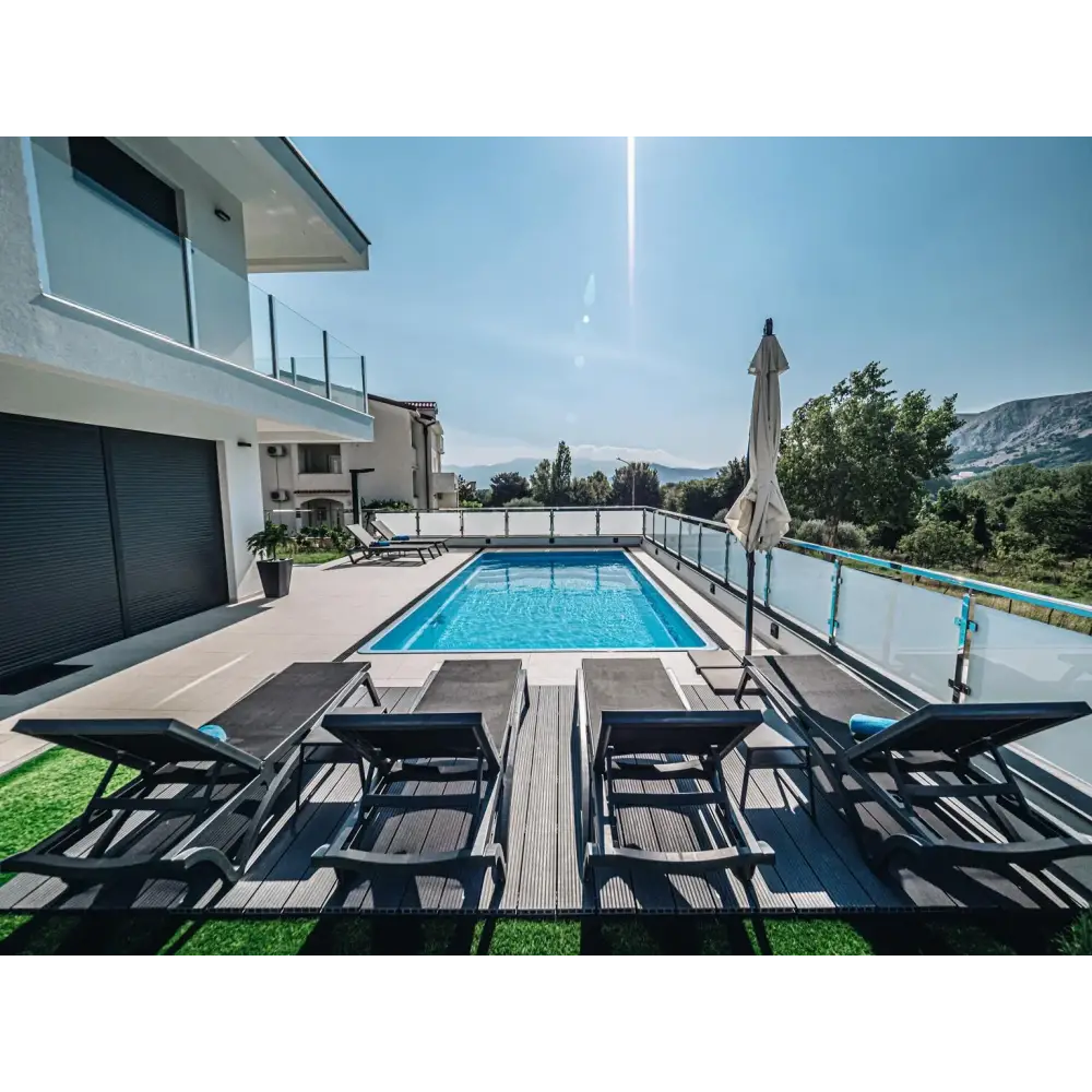 Rektangulär blå Glasfiberpool Aruba 800 med klart vatten och glasräcke